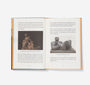 Open book with text and images of sculptures on a white background
