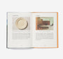 Open book with images of a ceramic plate and a room interior on a white background