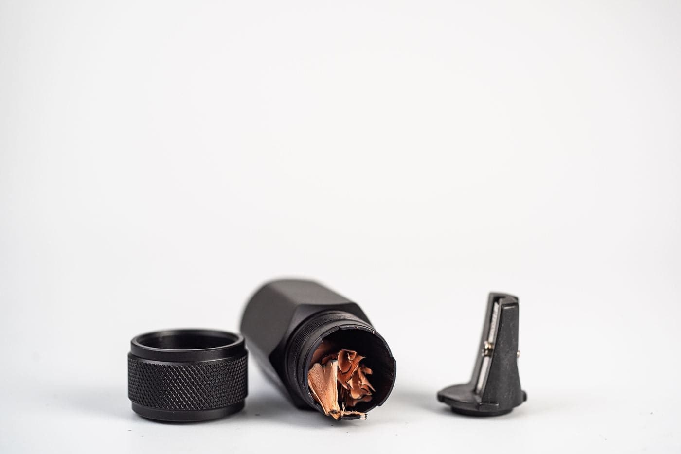 Black metal cylindrical component with internal wiring on a white background