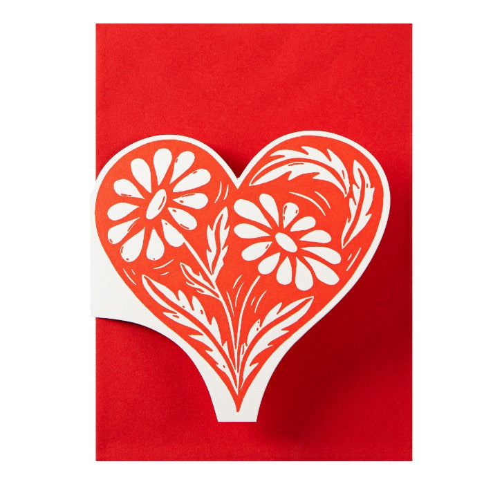 White floral heart design on a red card