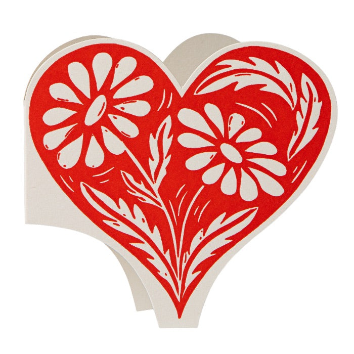 Red heart-shaped decorative item with white floral patterns on a white background