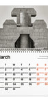 A spiral-bound calendar page featuring a large black-and-white architectural photograph of a concrete building on the top half, with a March calendar grid on the bottom half. The days of the week are printed in black, with Sundays highlighted in red-orange.