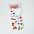 A sheet of colorful stationery stickers on a white backing card, photographed on a plain white background. The header reads 'Stationery Store Day' and the stickers include paperclips, scissors, stars, hearts, pencils, and cartoon foxes.