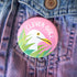 Pink button with 'Clever Gull' logo on a denim jacket