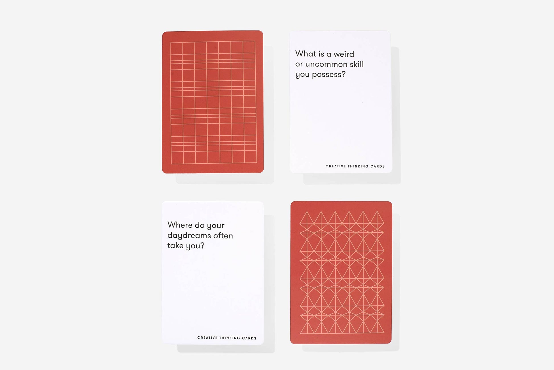 Two red playing cards with geometric patterns on a white background