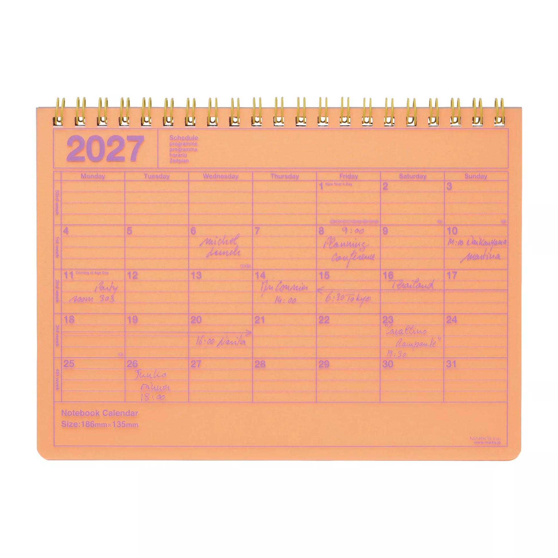 An orange 2027 spiral-bound desk calendar with pink printed grid lines and handwritten notes in purple ink, shown on a white background.