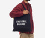 Person holding a black tote bag with 'EMOTIONAL BAGGAGE' text on a white background