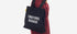 Person wearing a black tote bag with 'EMOTIONAL BAGGAGE' text on a white background