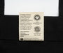 Label on a black garment with text about organic cotton and fair trade practices.