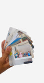 Hand holding a stack of photo cards with images on a white background