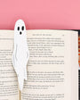 Ghost-shaped bookmark in an open book with a pink background
