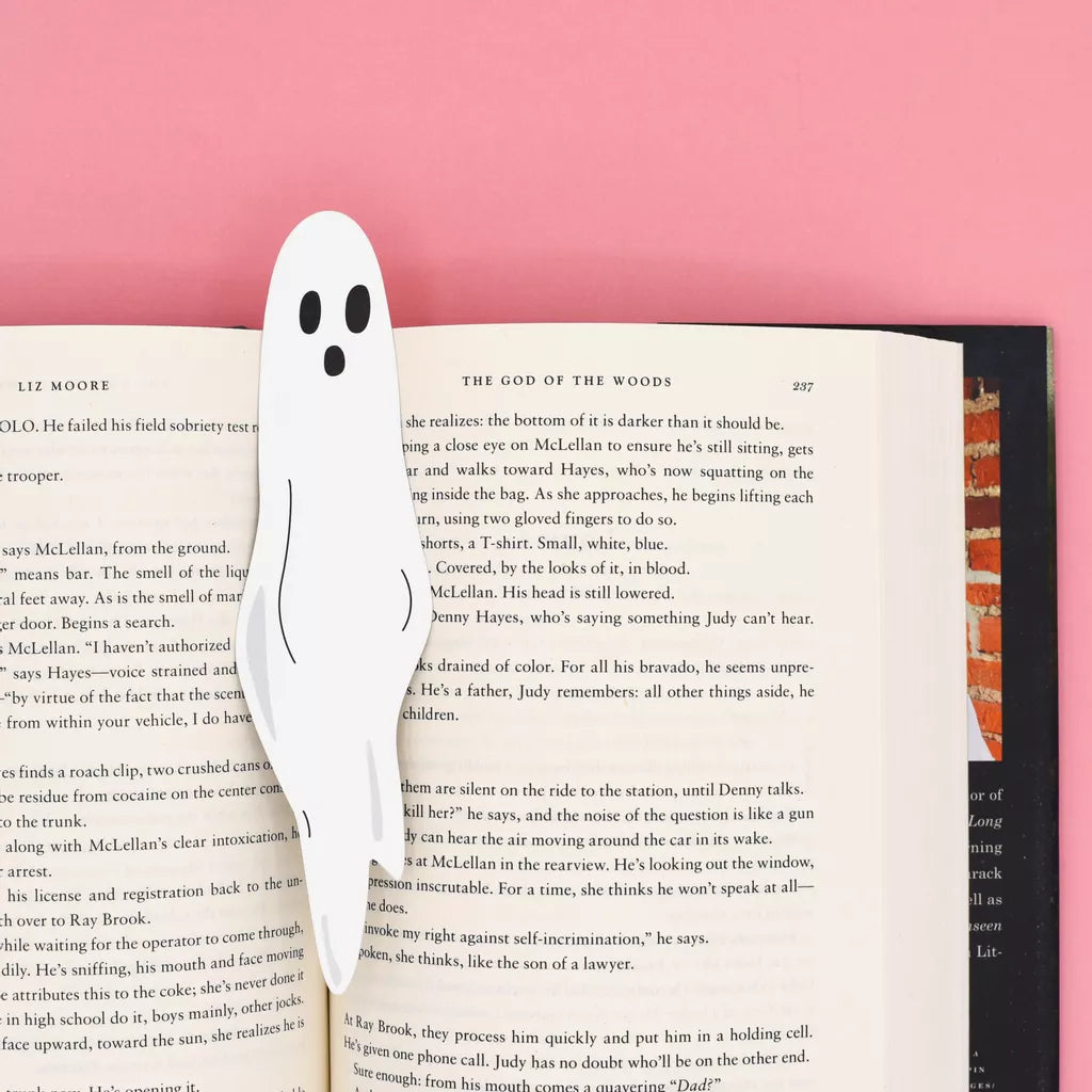 Ghost-shaped bookmark in an open book with a pink background