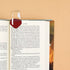 Open book with a wine glass bookmark on a beige background