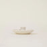 White ceramic dish with a small cup on a light beige background