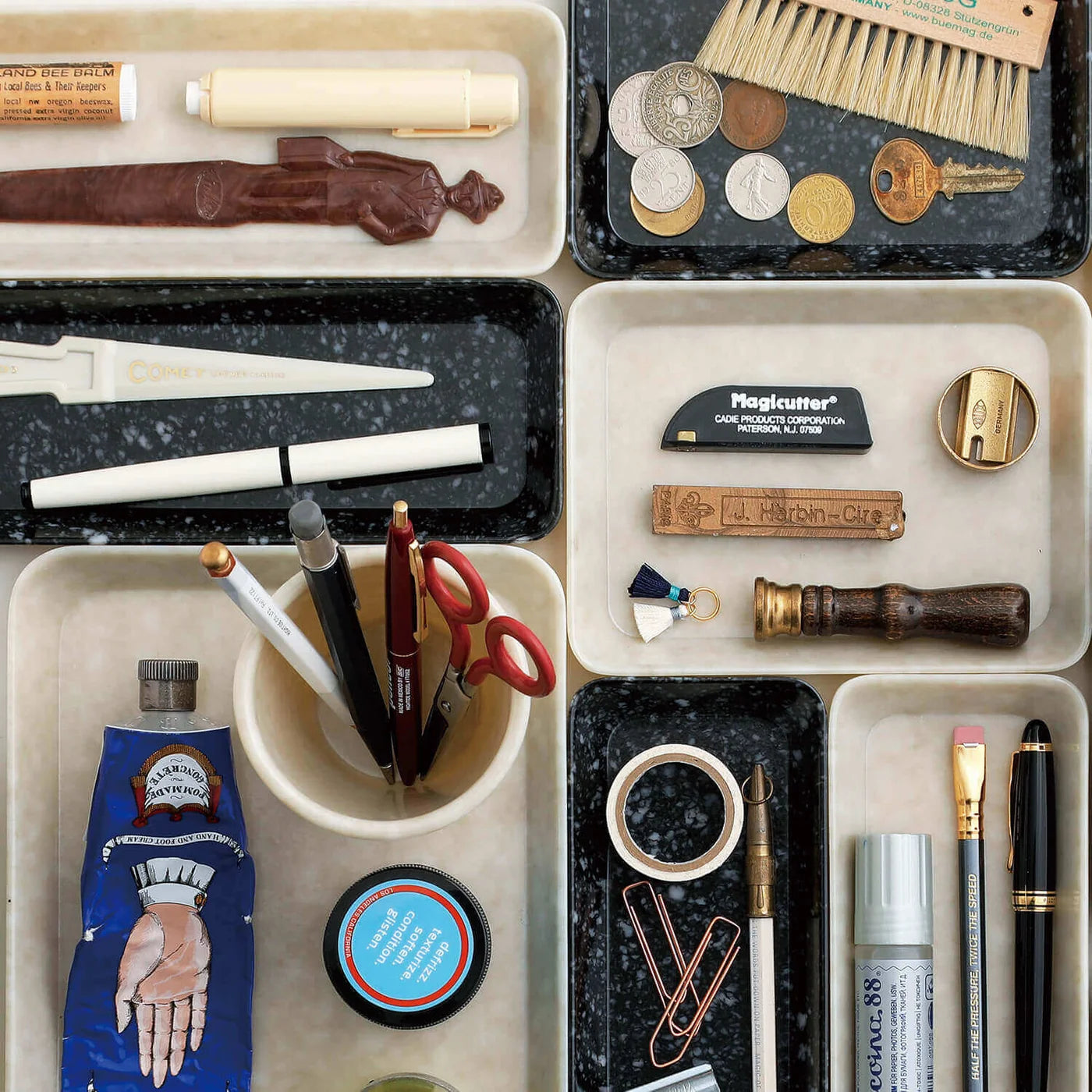 Collection of stationery items including pens, markers, and brushes in various holders.