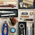Collection of stationery items including pens, markers, and brushes in various holders.