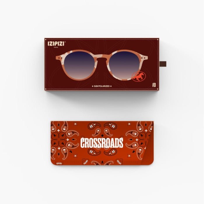 Izipizi Sun Polarized sunglasses shown with their packaging, featuring a reddish-brown box with a graphic of the sunglasses and a matching brown patterned pouch below.