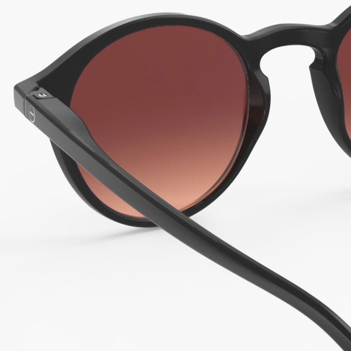 Black sunglasses with brown gradient lenses on a white background