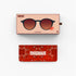 Two rectangular accessory boxes shown on a light gray background: the top box is pale peach with an illustration of round sunglasses and the brand name IZIPIZI; the bottom box is red with a paisley pattern and the word CROSSROADS. No person, animal, or real environment is present, so this is Product/Packaging.