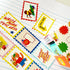 A close-up of colorful educational bookmarks or bookmark cards laid out on lined paper. The cards have scalloped edges and cartoon illustrations, including a red stamp-like card reading 'WRITE MORE TEXT LESS,' a yellow arrow card reading 'TRY MORE,' a blue border card with a snail, a fox, and a starburst card reading 'TODAY ONLY!'.