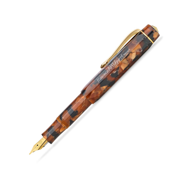 A Kaweco Art fountain pen with a tortoiseshell patterned barrel in brown and amber tones, accented with gold-toned metal trim and clip, and a gold nib at the tip.
