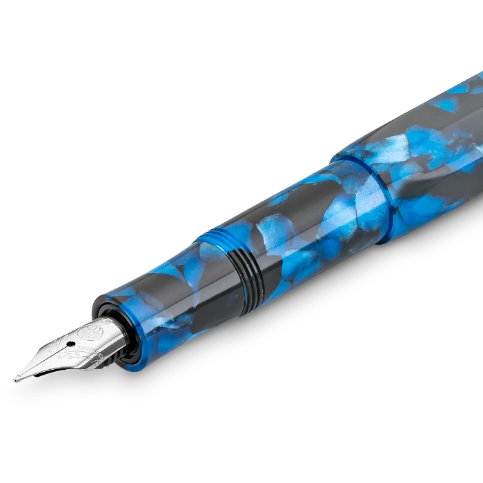 A close-up of a fountain pen with a blue and black marbled pattern, featuring a silver nib at the tip, set against a plain white background.