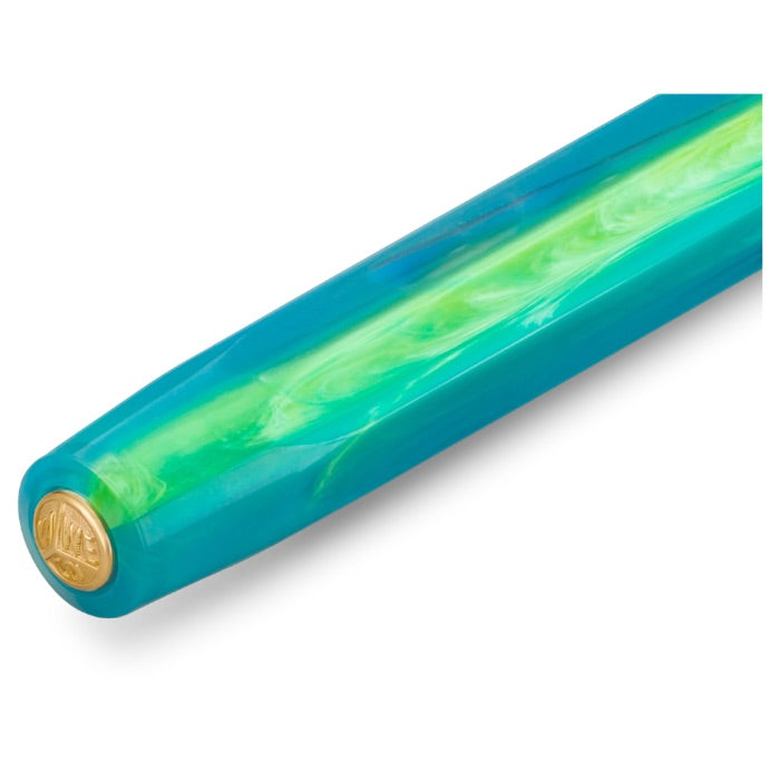 A close-up of a glossy turquoise and green marbled rod, likely a pen or tool handle, featuring a gold circular emblem at the rounded end, set against a plain white background.