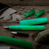 Green fountain pens and components on a wooden surface