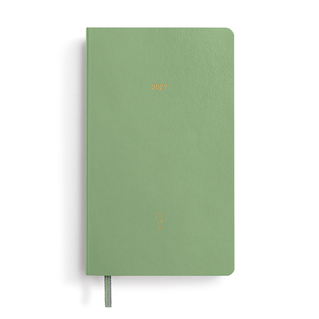 Green notebook with gold embossed text on a white background