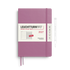 A Leuchtturm1917 2027 weekly planner in a dusty purple/magenta color, shown with its white paper band and a white pen on a clean white background.