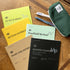 Collection of notebooks and a pen on a wooden surface