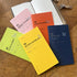 Collection of colorful planners and notebooks on a wooden surface