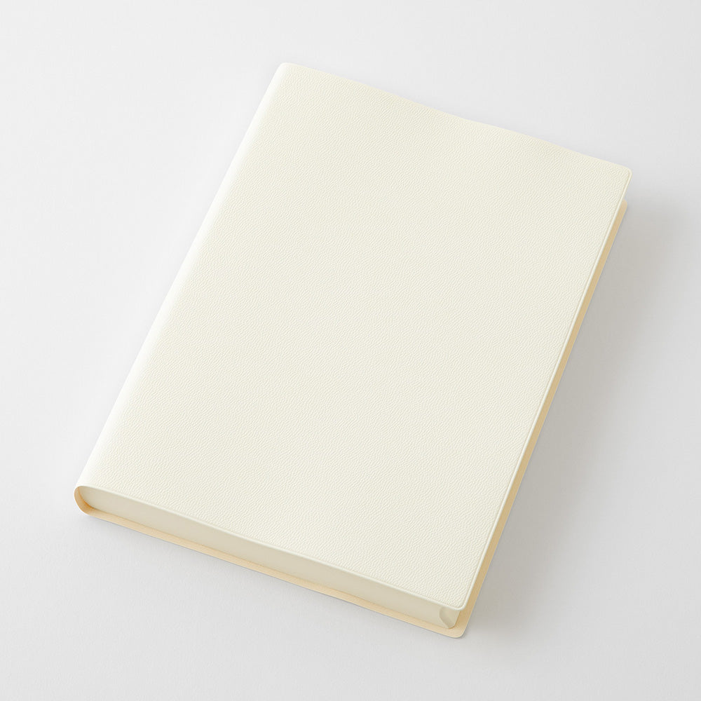 A blank cream-colored softcover notebook or journal with a textured cover, shown at an angle on a clean white background.