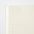 A close-up of a cream-colored notepad or planner page with printed black text placeholders and numbered lines on a white background.