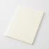 A blank cream-colored notebook or journal with a white binding edge, shown at an angle on a light gray background.