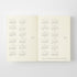 An open cream-colored planner or calendar showing printed monthly calendar grids for 2017 and 2026 on both pages, photographed against a light gray background.