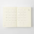 An open cream-colored planner or journal showing two monthly calendar spreads for January, photographed against a clean white background.