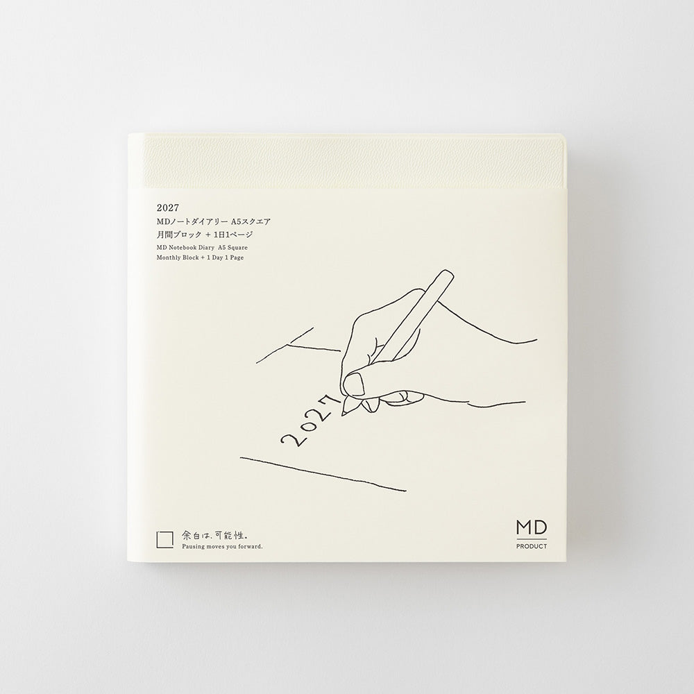 A square cream-colored notebook or planner cover with minimalist black line art of a hand writing '2021' and small printed text, shown against a light gray background.