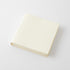 A blank cream-colored square photo album or notebook with a hard cover, shown at an angle on a light gray background.