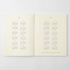 An open two-page calendar or planner spread on a light gray background. The pages are warm off-white/cream with printed calendar grids for 2017 on the left page and 2018 on the right page.