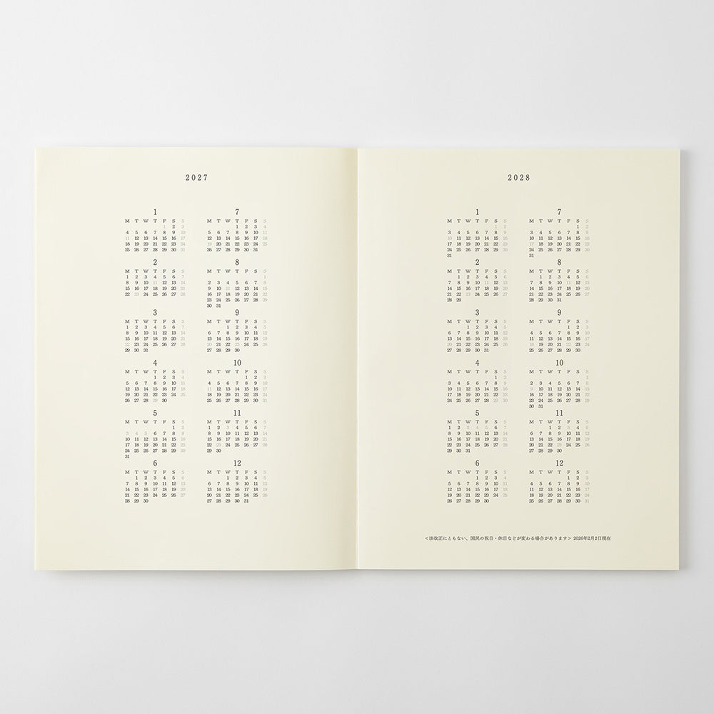 An open two-page calendar or planner spread on a light gray background. The pages are warm off-white/cream with printed calendar grids for 2017 on the left page and 2018 on the right page.