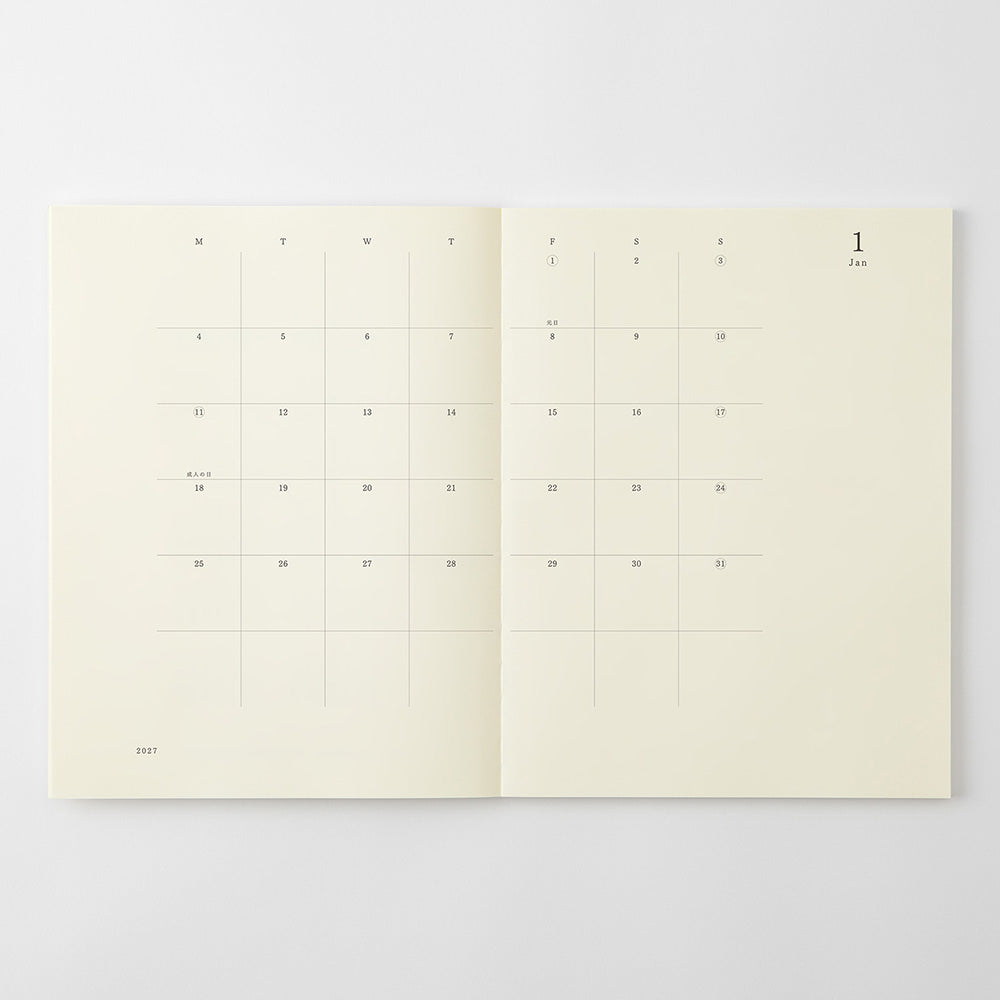 An open cream-colored planner or notebook showing minimalist monthly calendar pages with dates and weekday grids on a light gray background.
