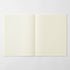 An open notebook with two cream-colored grid pages, displayed flat against a light gray background.