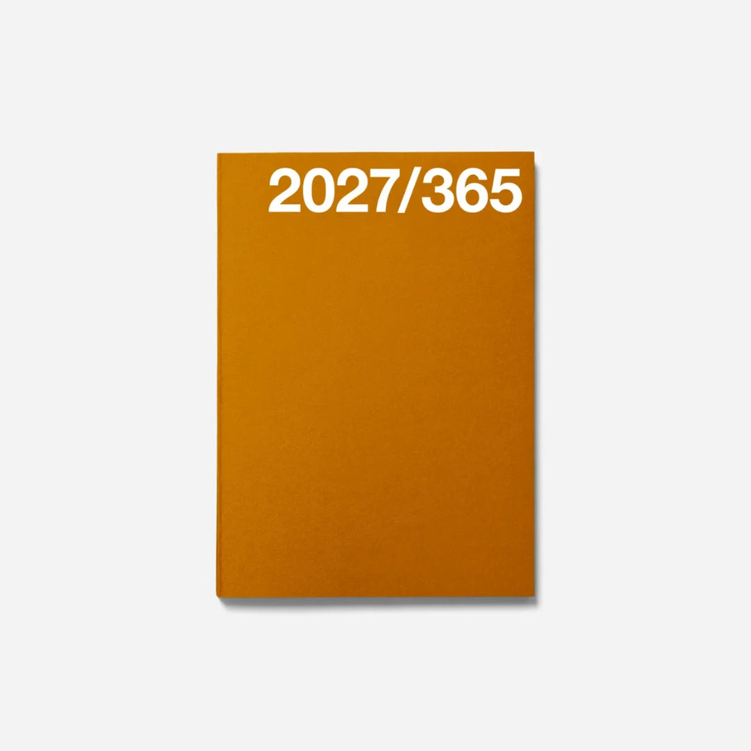 A minimalist orange notebook or planner cover with the white text '2027/365' printed at the top, shown against a clean light gray background.