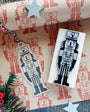 Wooden nutcracker stamp and matching tag on a decorative paper background