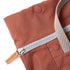 Close-up of a brown fabric bag with a silver zipper on a white background