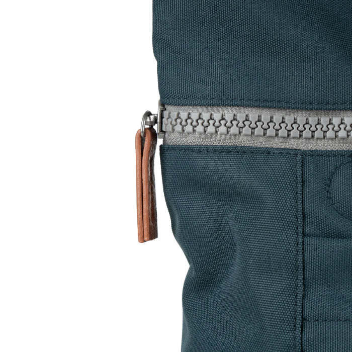zip close up of dark grey coloured backpack on a white background