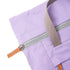 Close-up of a purple bag with a zipper and brown handle on a white background