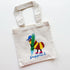 A natural canvas tote bag with a colorful cartoon bee holding a green pencil and the word 'Supplies' printed in blue script, shown on a plain white background.
