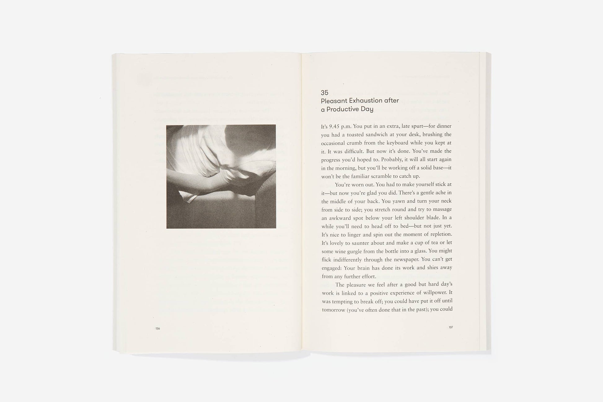 Open book with a black and white photograph on the left page and text on the right page.